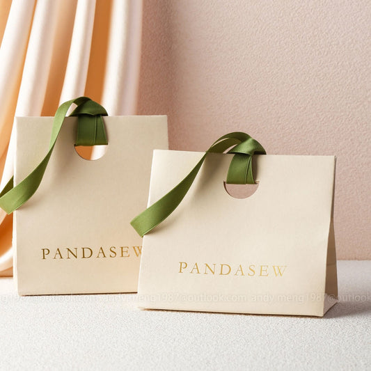 beige paper gift bags with green ribbon