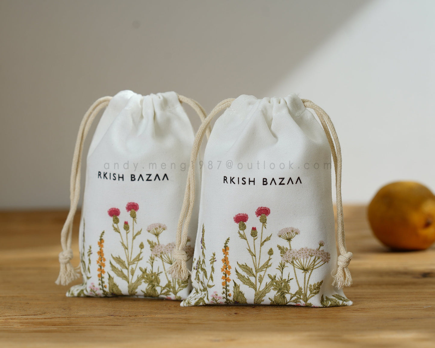 white cotton canvas pouch with gold logo and light beige cotton string