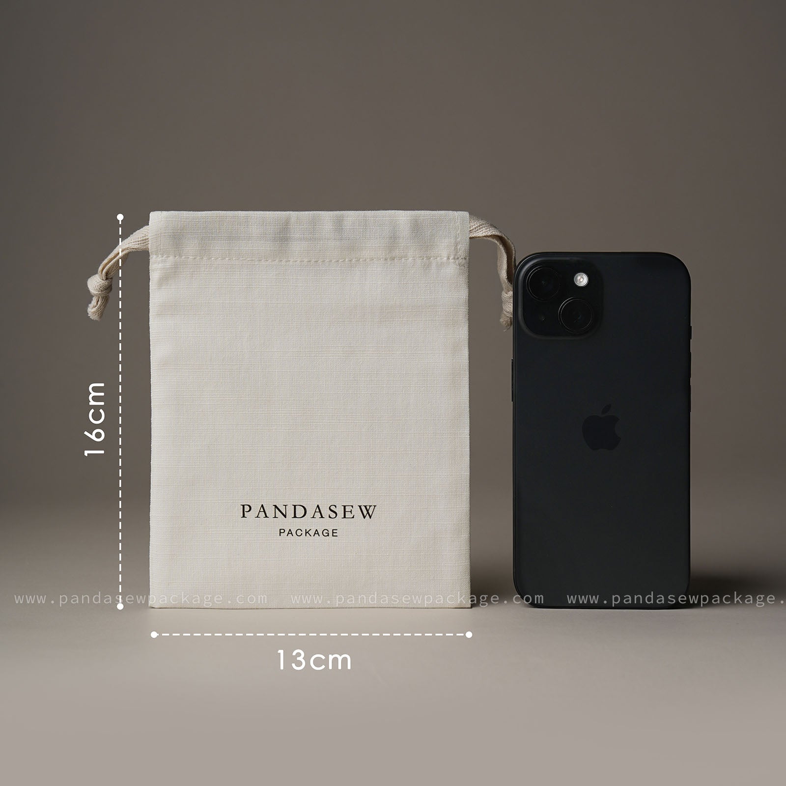 Size comparison. Medium 13x16cm drawstring bag shown next to an iPhone to demonstrate capacity.