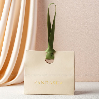 beige paper gift bags with green ribbon