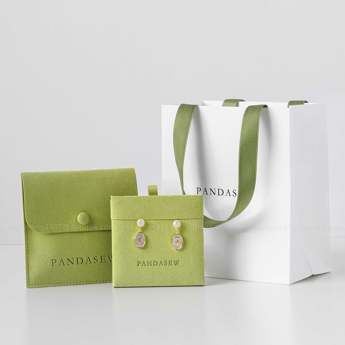 white gift bag with green jewelry displayer