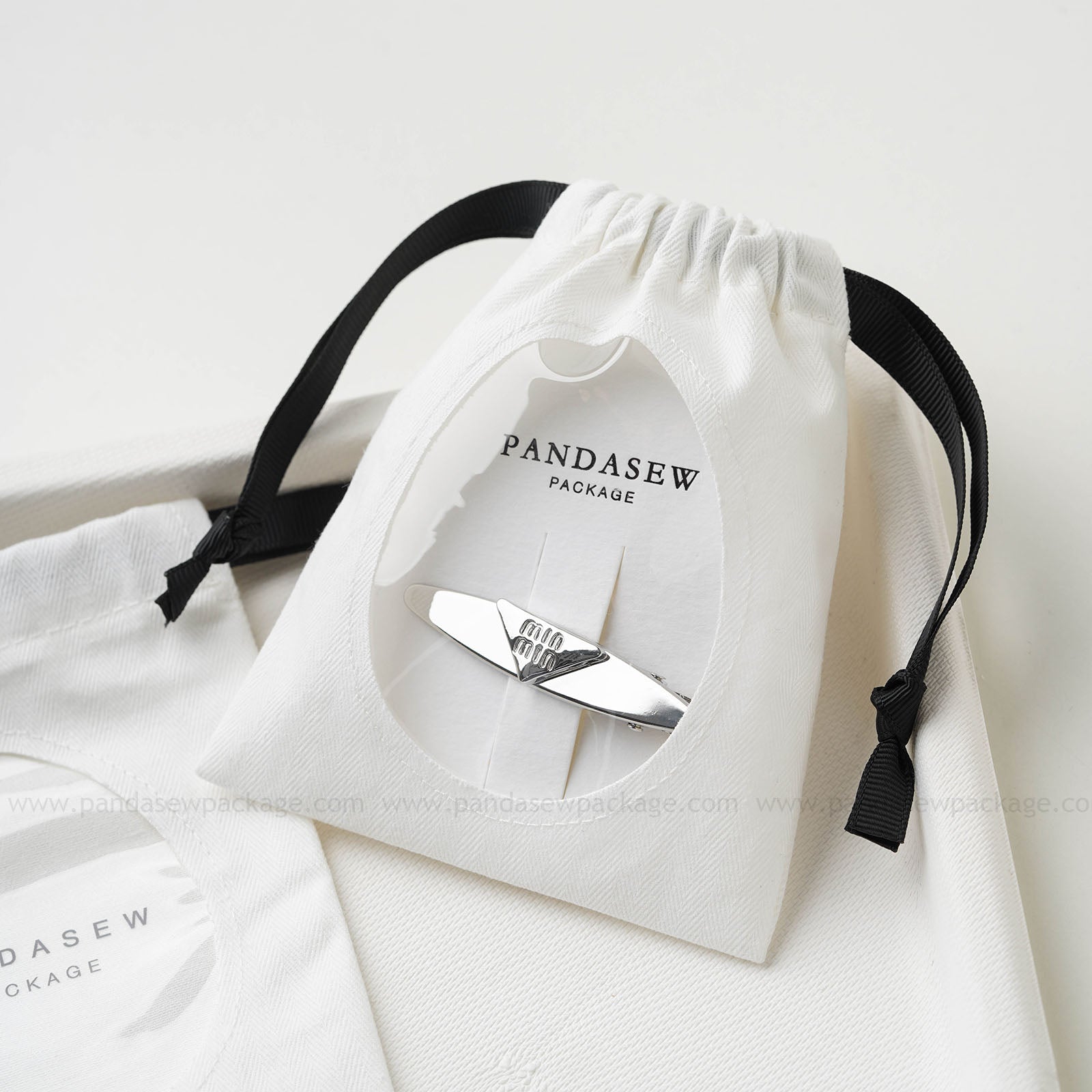 Cotton jewelry drawstring bag with custom logo and ribbon closure, suitable for earrings and bracelets, showcased by Pandasew Package.