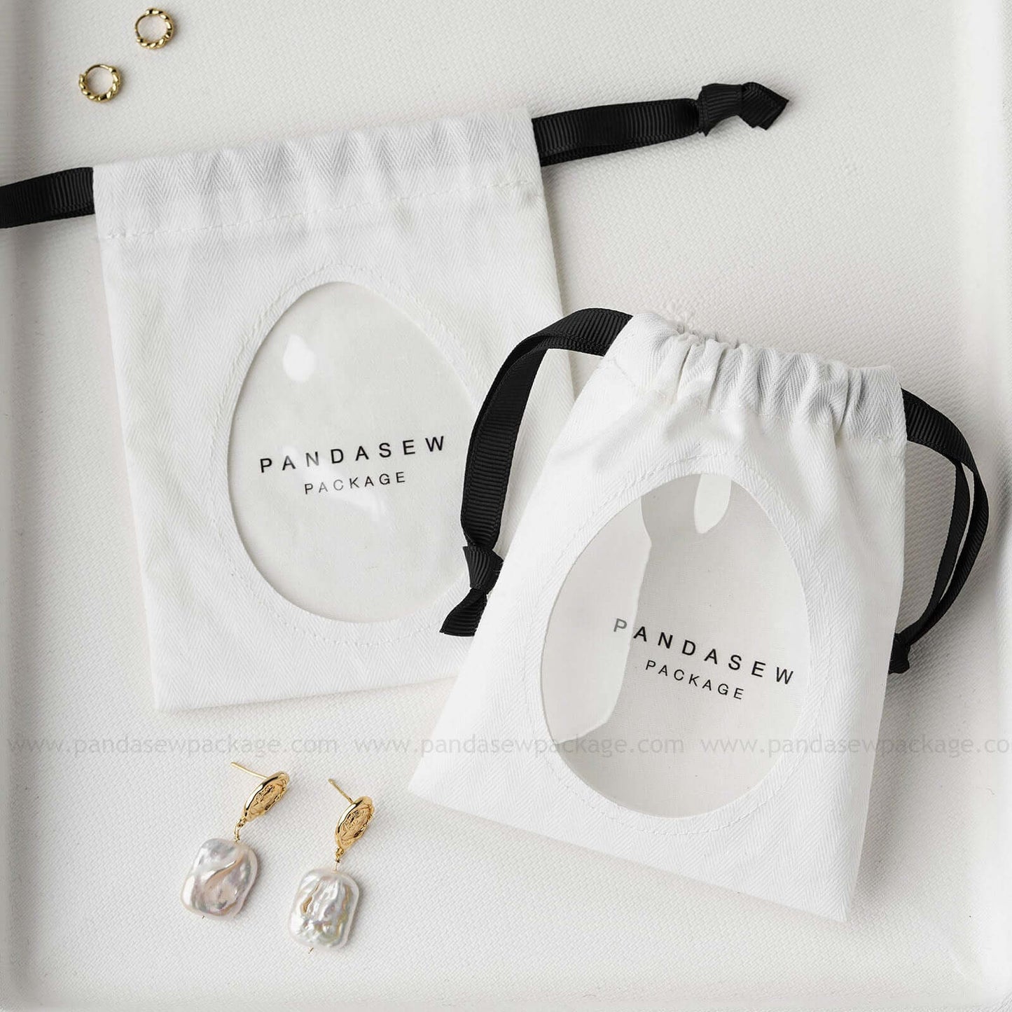 Cotton jewelry drawstring bags with custom logo, featuring transparent windows. Eco-friendly earring and bracelet packaging.