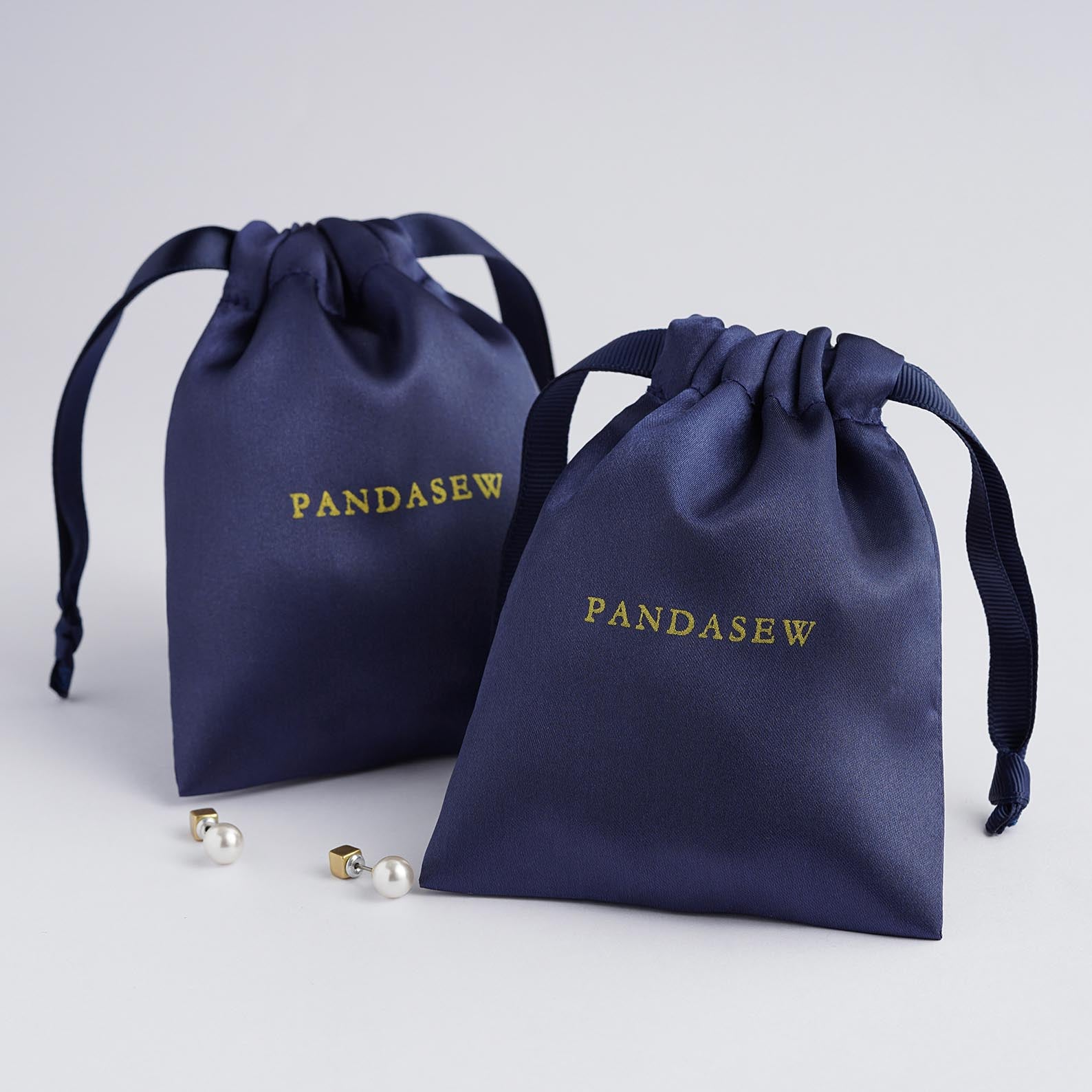 navy blue color satin, shiny satin bag with silver logo, candles, soap packaging