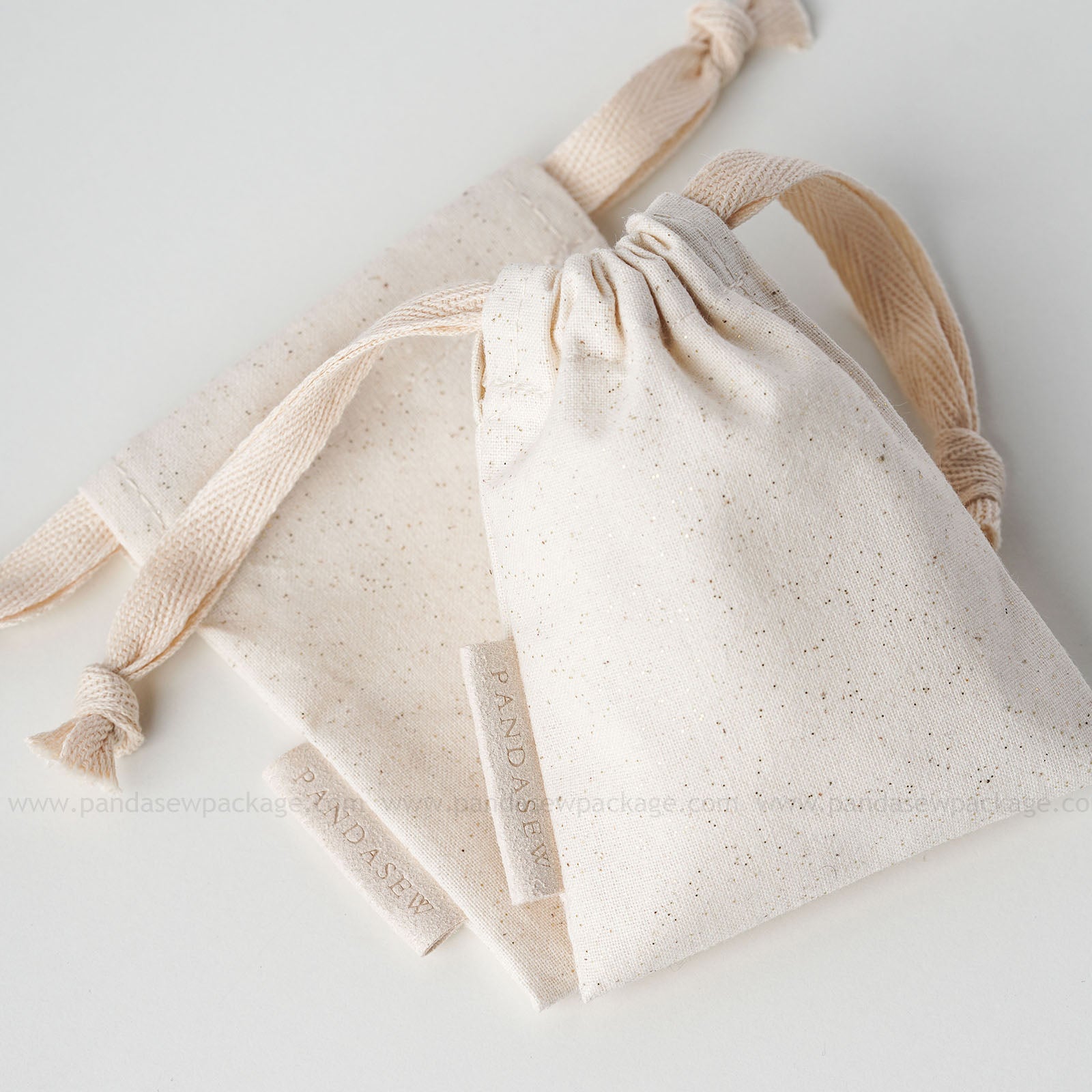 beige cotton drawstring bag with label