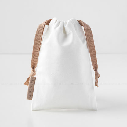 white canvas drawstring bag with label