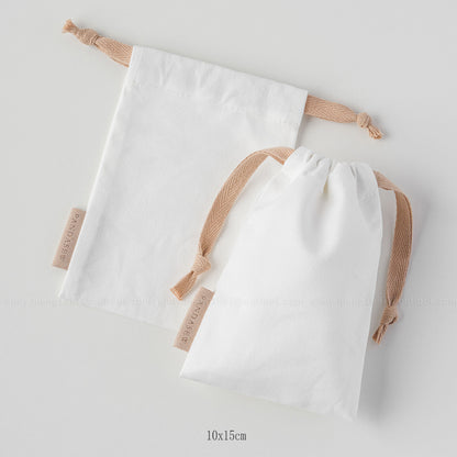 white canvas drawstring bag with label