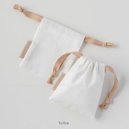 white canvas drawstring bag with label