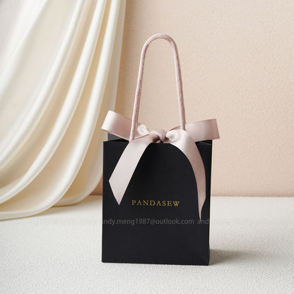 black paper bags with pink handles