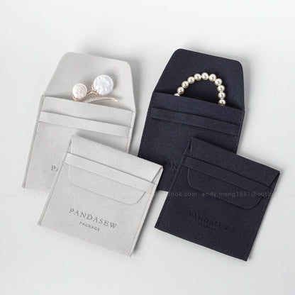 gray and navy jewlery pouch with logo, leather bag