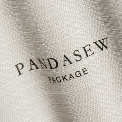 Close-up of custom logo printing on fabric. Crisp black ink branding on textured off-white cotton linen background