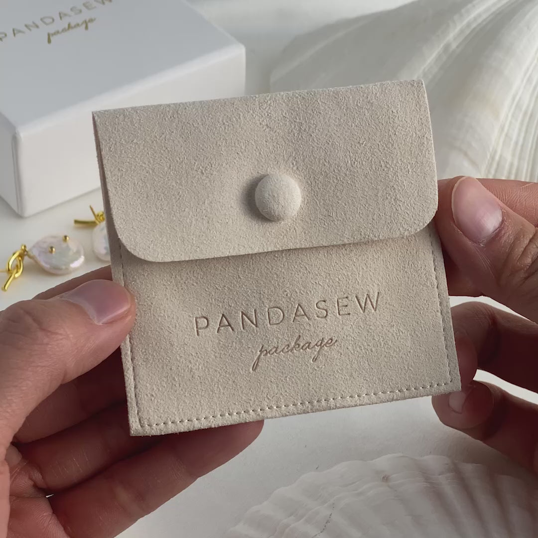 button bag in sand color, white jewelry box. branded logo pouch