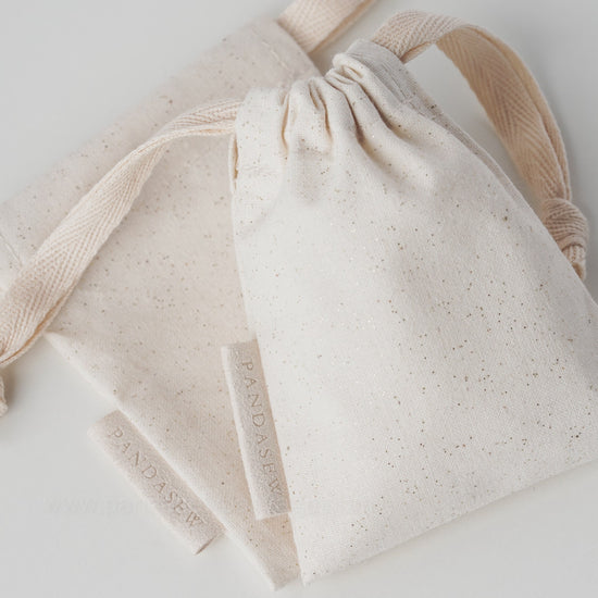 beige canvas drawstring bag with label