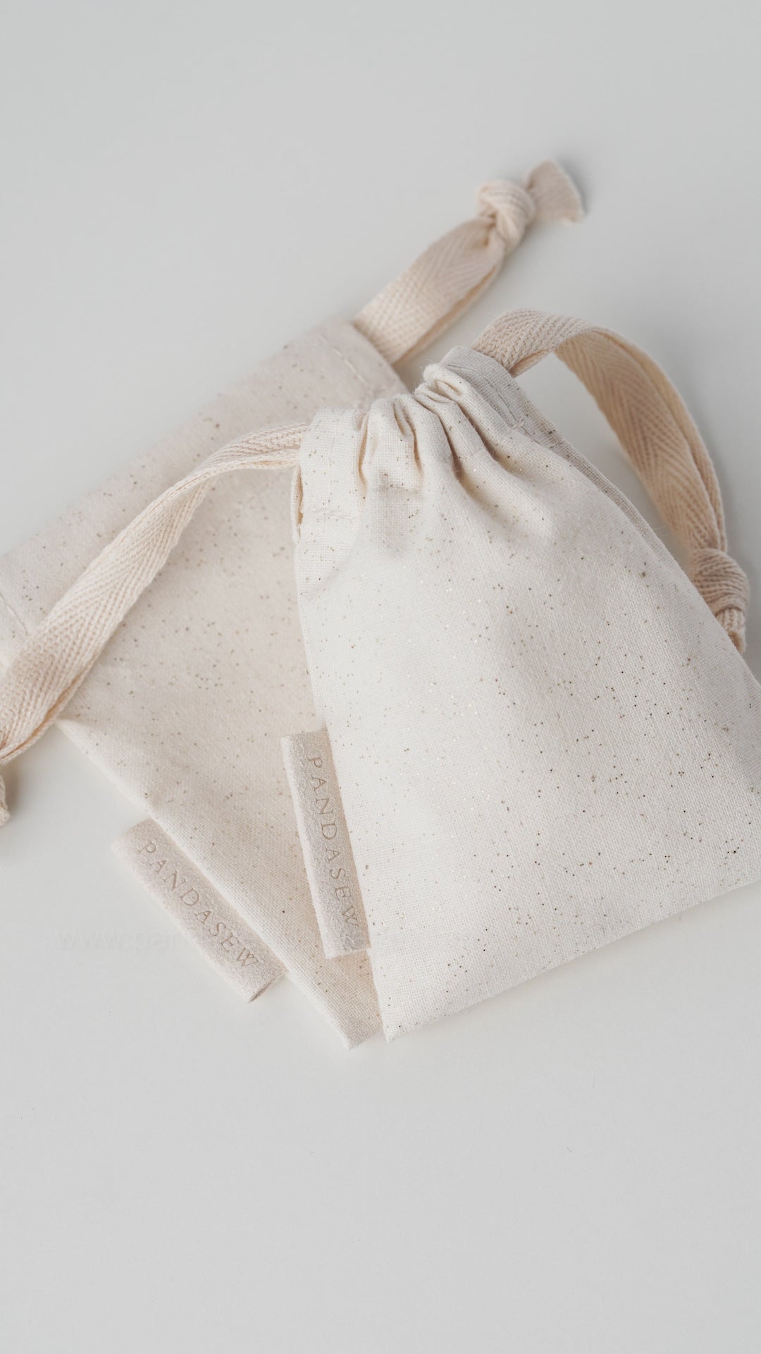 beige canvas drawstring bag with label
