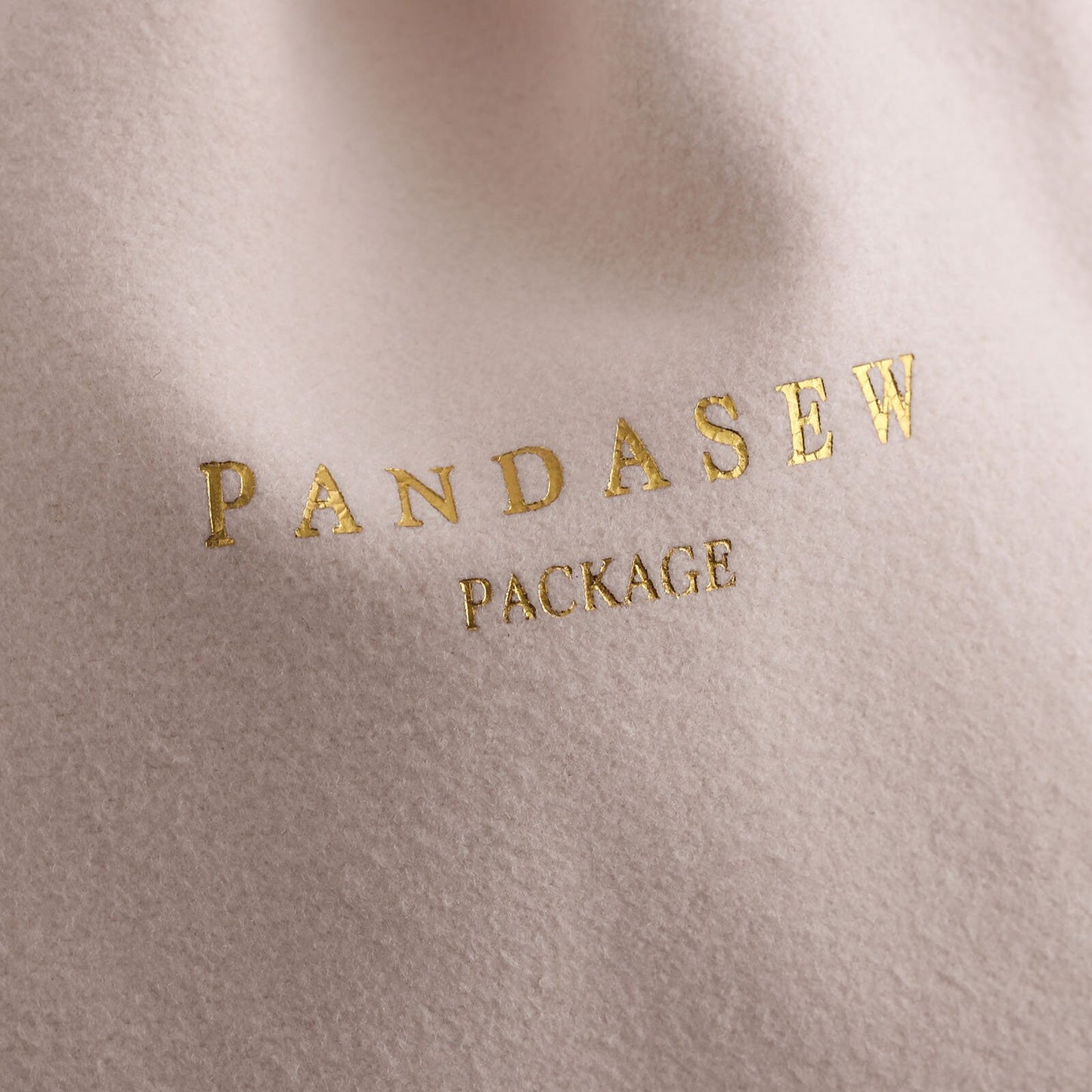 beige velvet pouch with gold foiled logo