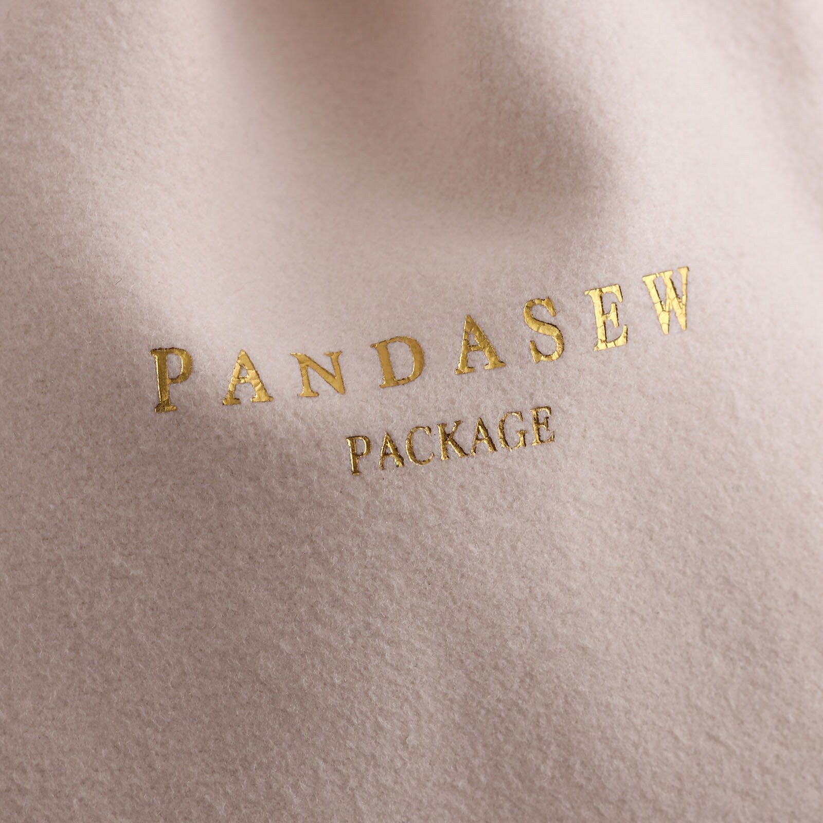beige velvet pouch with gold foiled logo