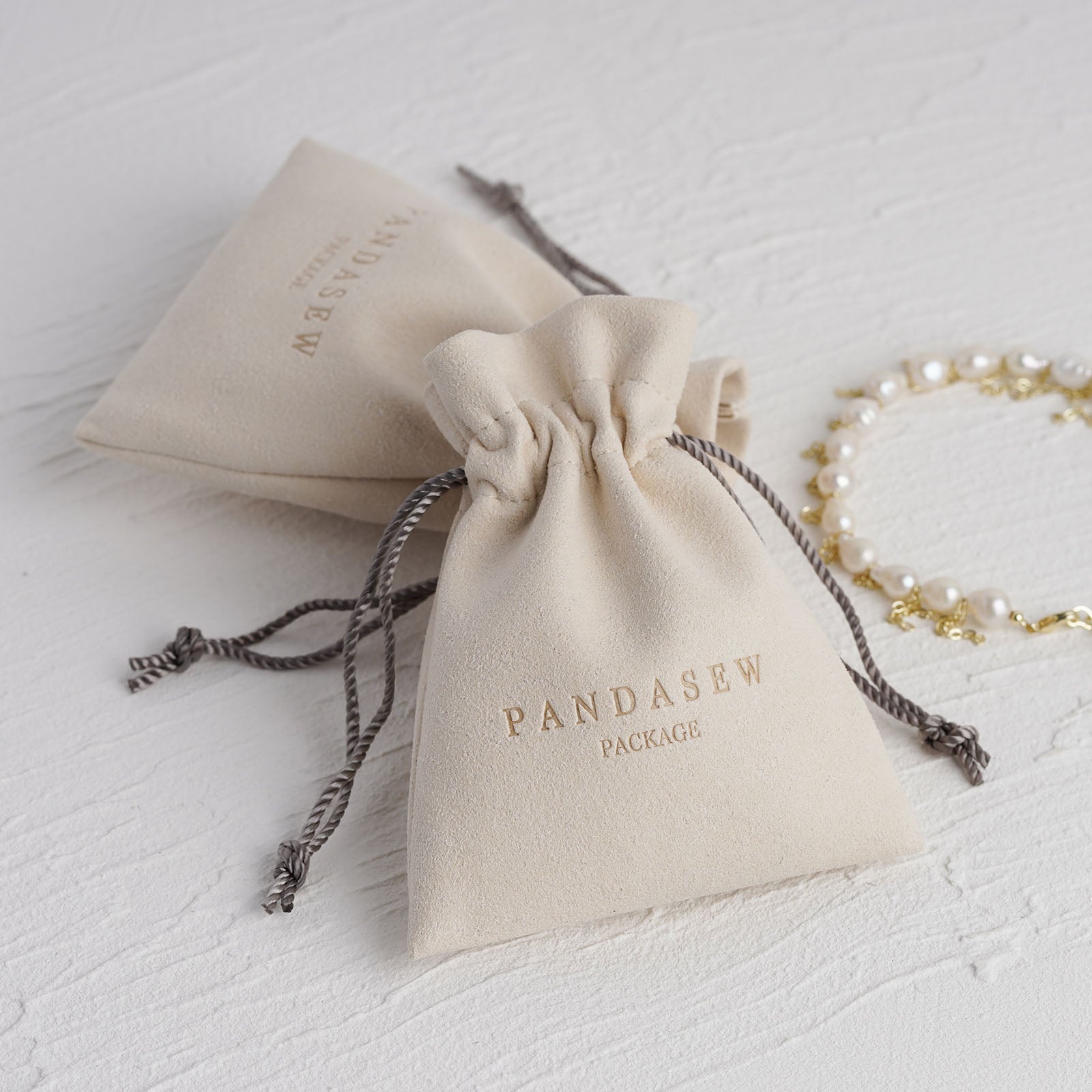 Beige microfiber pouch drawstring style deboss logo